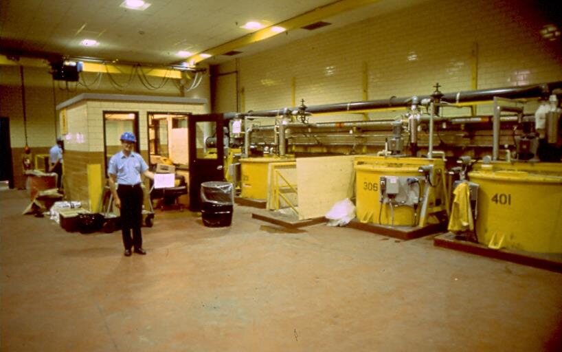 Refinery hall with an operator and process tanks