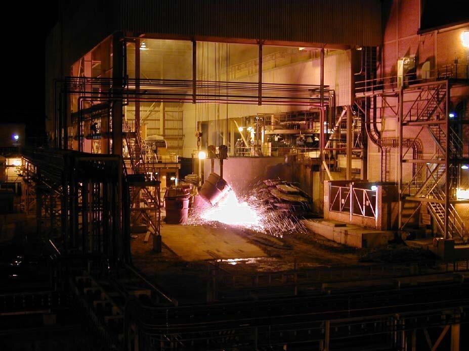 Furnace building lit by molten slag at night
