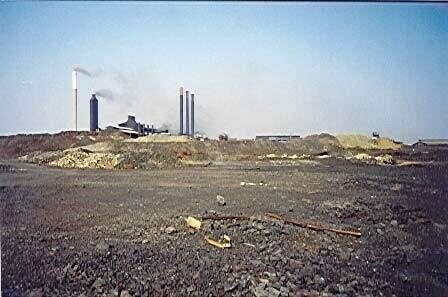 Slag dumps with smelter stacks in the distance